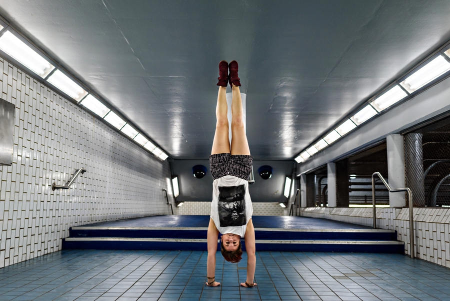 A woman doing a handstand in the subway in philly.